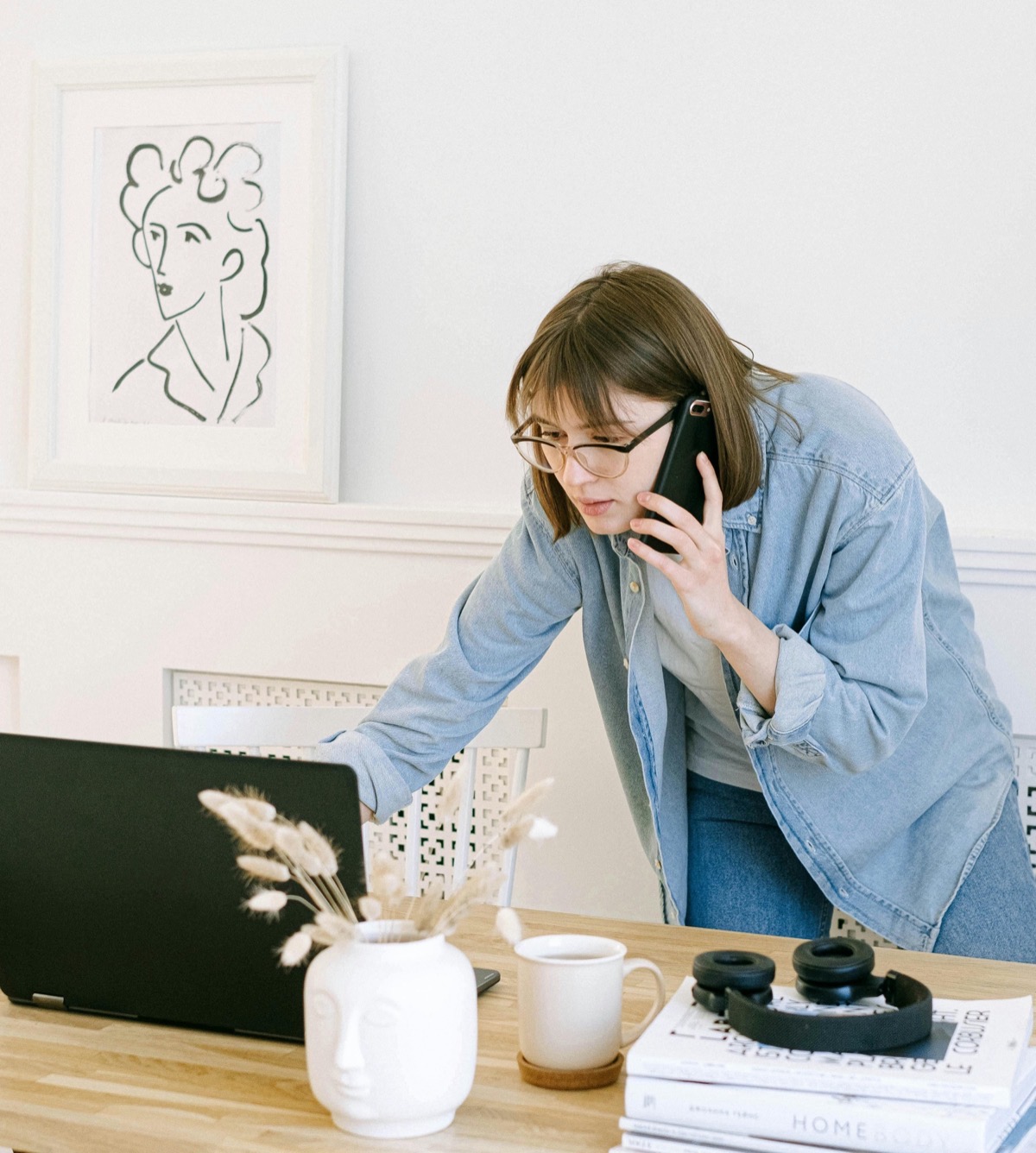Business owner on the phone while multitasking at her desk